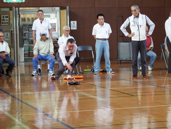 真剣にストーンを送り出す選手。ストーンのラインをよく読んで スライスかフックか投げ出す場所も工夫して右から、左からとプロも真っ青。