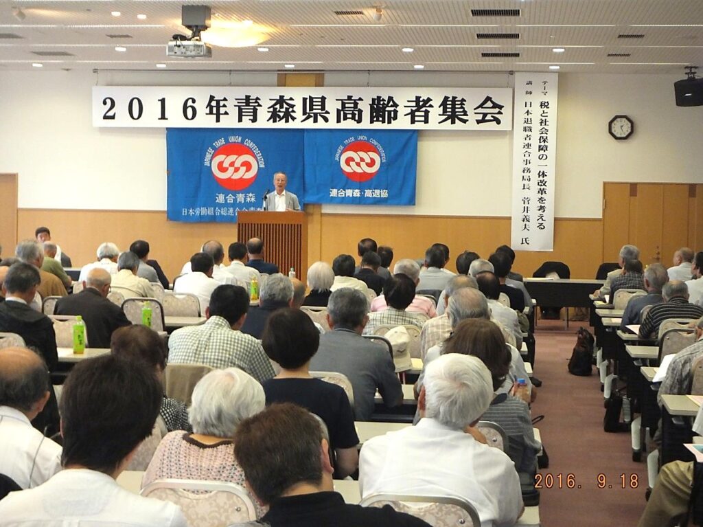 講演する菅井事務局長