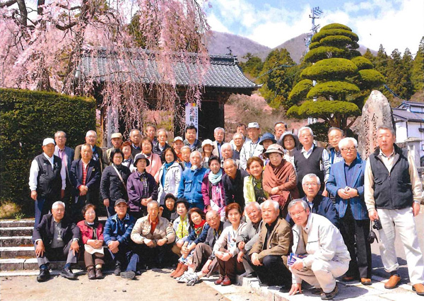 天気にも恵まれてしだれ桜の下、参加者全員で「ハイ！ぱちり」。 （４月１１日、長野・駒ヶ根の光前寺山門前で）