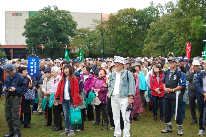 雨も上がり参加者であふれた出発式。最高齢は９４歳の会員。